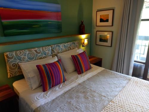a bedroom with a white bed with two pillows at Casa Verde Río in Rio de Janeiro