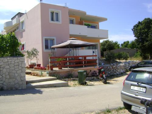 ein Haus mit einem Regenschirm und einem davor geparkt in der Unterkunft Apartments Sanja in Hvar