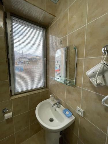 a bathroom with a sink and a mirror and a window at Apartment in Gudauri in Gudauri