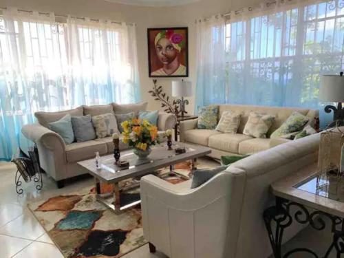 a living room with two couches and a table at Bella Vista Vacation in Montego Bay
