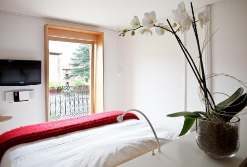 a vase with white flowers on a table next to a window at Hotel Echaurren Relais & Châteaux in Ezcaray