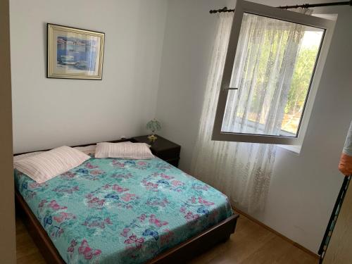 een slaapkamer met een bed en een raam bij Apartman Ruža in Brzac