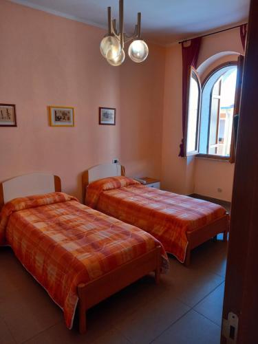 a hotel room with two beds and a window at Affittacamere Su Padru in Ittiri