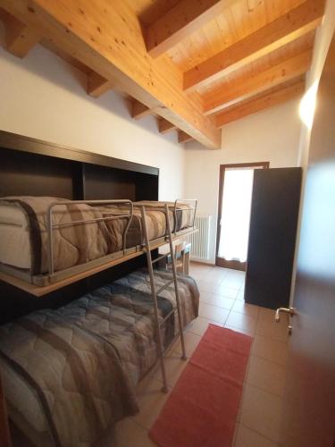 una camera con letti a castello in una stanza con soffitti in legno di Residence Cime d'Oro ad Andalo