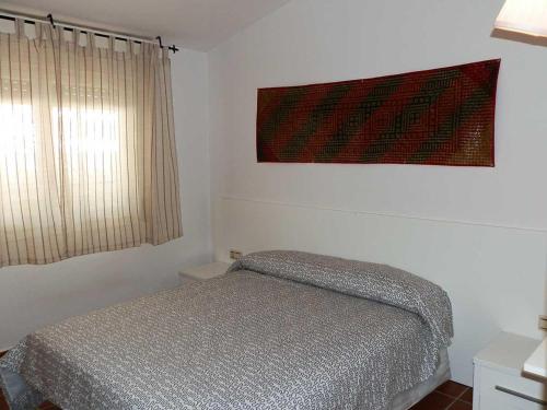 1 dormitorio con 1 cama y una foto en la pared en Casa Deltebre, 2 dormitorios, 4 personas - ES-184-14, en Riumar