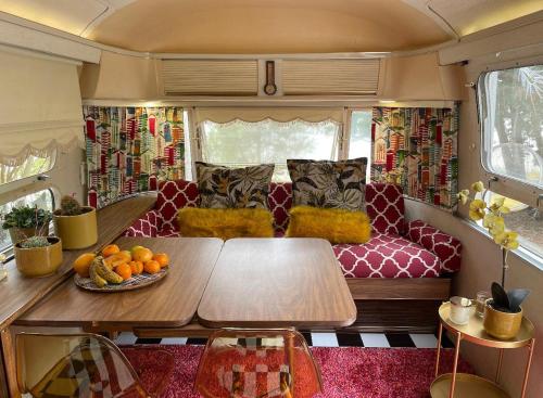 a living room with a table and a couch in an rv at Amy The Airstream At Aloe Fjord in Vaal Marina