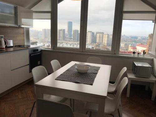 a table and chairs in a kitchen with a view of the city at Centrum in Belgrade