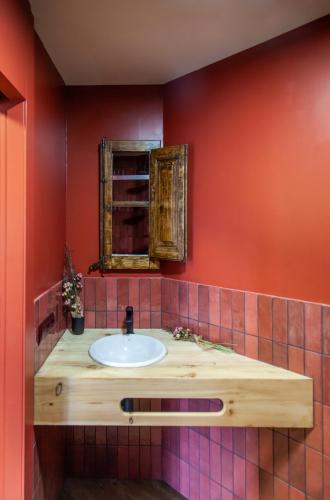 a bathroom with a sink and a mirror at Casa amb jacuzzi privat, Cal Rossa in Tahús