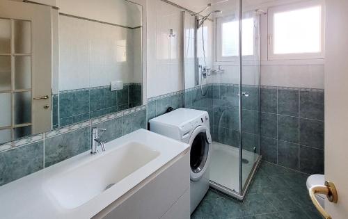 a bathroom with a sink and a washing machine at Spacious apartment at Como lake in Mandello del Lario