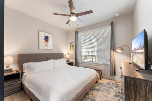 een slaapkamer met een bed en een plafondventilator bij Luxury Central Apts - Free Parking, Gym, Fast WiFi in Austin
