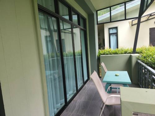 a balcony with a blue table and two chairs at Snapper House in Khao Lak