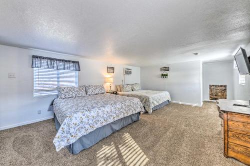 a bedroom with two beds and a flat screen tv at Bright 2-Story Condo 8 Mi to Grindstone Lake in Ruidoso Downs