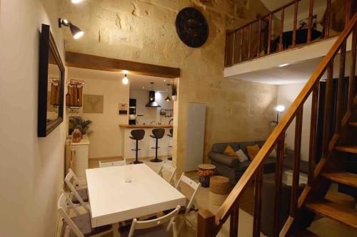 ein kleines Wohnzimmer mit einem Tisch und einer Treppe in der Unterkunft Gîte au cœur des vignes in Bourg-sur-Gironde