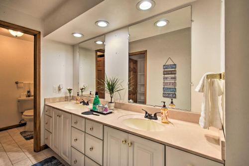 a bathroom with two sinks and a large mirror at Ortonville Retreat with 2 Decks and Lake Access! in Ortonville