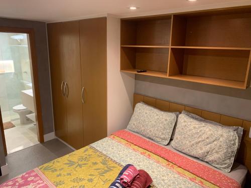 a small bedroom with a bed and wooden cabinets at Flat completo no Life Resort in Brasilia