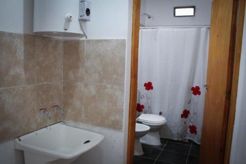 y baño con aseo, bañera y lavamanos. en Departamento Génesis, 1er piso en Chilecito