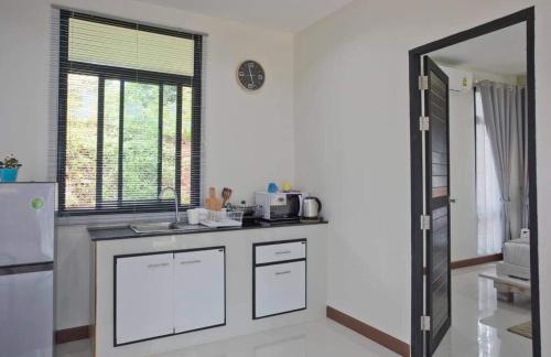 a kitchen with a counter and a sink and a window at Snapper House in Khao Lak