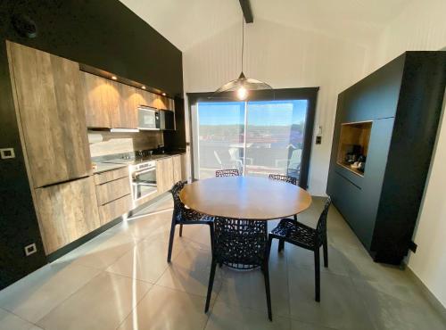 une cuisine avec une table et des chaises dans une pièce dans l'établissement Villa Palot à la plage, à Mimizan