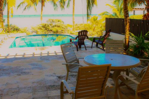 a patio with chairs and a table and a swimming pool at Paros a gulf of Mexico paradise in Uaymitun