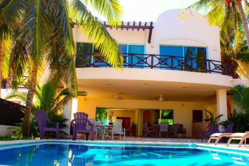 a villa with a swimming pool in front of a house at Paros a gulf of Mexico paradise in Uaymitun