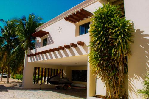 a white house with palm trees in front of it at Paros a gulf of Mexico paradise in Uaymitun