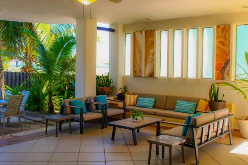 a lobby with a couch and chairs and palm trees at Paros a gulf of Mexico paradise in Uaymitun