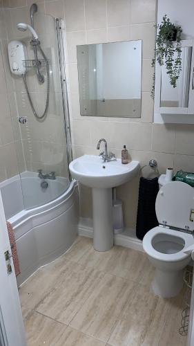 a bathroom with a sink and a toilet and a tub at Monkbridge York City Centre with parking in York