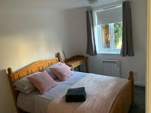 a bedroom with a bed with pink pillows and a window at Monkbridge York City Centre with parking in York