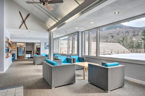 a waiting room with chairs and a table and windows at Lincoln Escape with Deck 1 Mi to Loon Mountain! in Lincoln