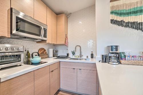a kitchen with a sink and a microwave at Cozy Flagstaff Studio with Patio - Near Dtwn! in Flagstaff