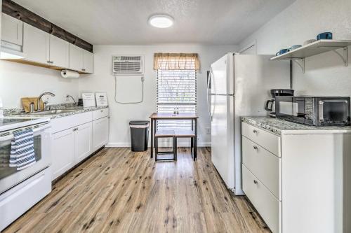 a kitchen with white cabinets and a wooden floor at Convenient Tom Picketts Cabin with Mtn View! in Ruidoso Downs
