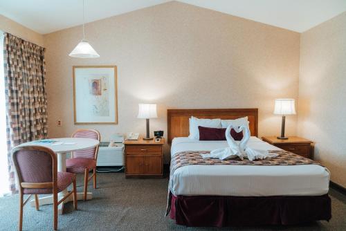 a hotel room with a bed and a table at Skaneateles Suites in Skaneateles