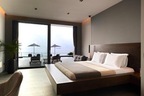 a bedroom with a large bed and a balcony at Villa OMNIA - Luxury Bound on Earth in Nea Moudania