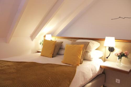 a bedroom with a bed with yellow pillows and two lamps at Living Aliados Mezzanine Flat W/ AC in Porto