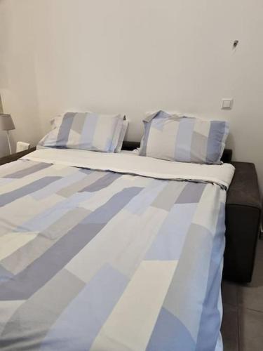 Modern studio apartment A في أثينا: سرير عليه بقع زرقاء وبيضاء ومخدات