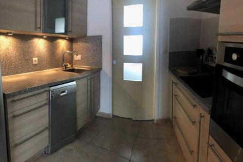 uma pequena cozinha com um lavatório e uma máquina de lavar louça em Saint Martin Appartement Duplex Proximité Immédiate Mer & Commerces em Bréhal