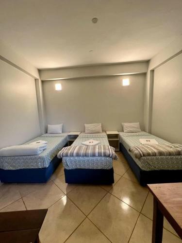 a room with three beds in a room at Hotel Catedral in Ciudad del Este