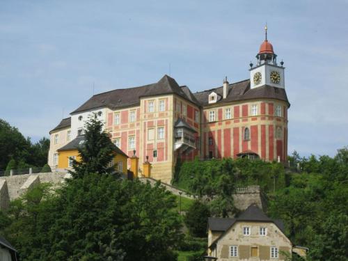 a large building with a clock tower on a hill at Dom Puchacza w Lądku-Zdroju in Lądek-Zdrój