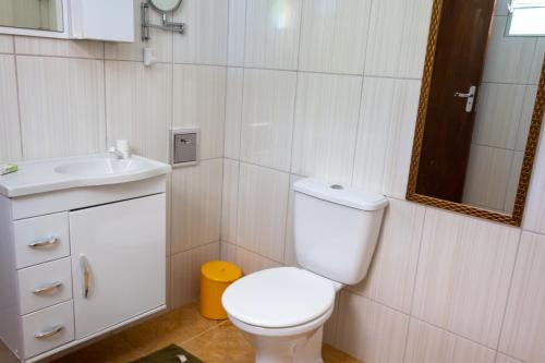 Un baño con un inodoro blanco y un lavabo. en Recanto do Zezé, en Gonçalves