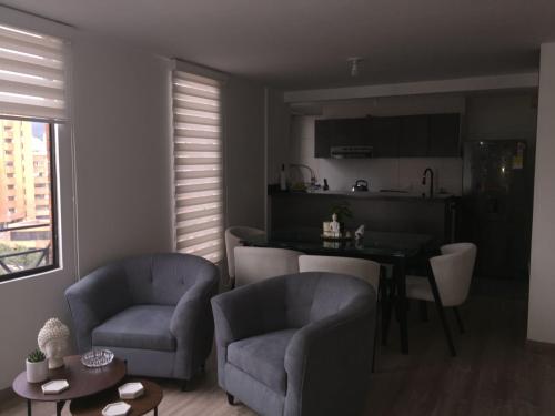 sala de estar con 2 sillas y mesa y cocina en Macondo-Habitación zona céntrica, en pleno corazón, en Bogotá