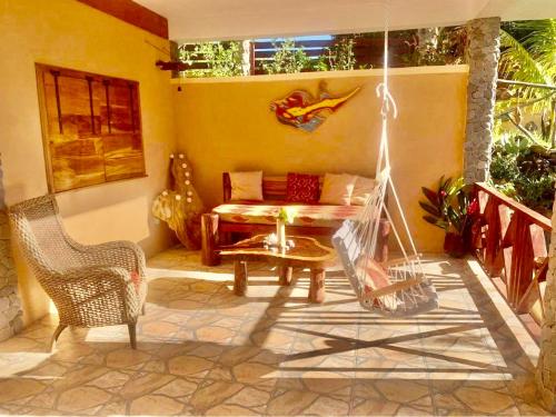 a porch with a swing and a couch at ORCHID RESORT Ltd in Guillet