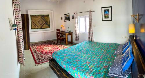 a bedroom with a bed and a table in it at Comfort and Cozy in Orchha