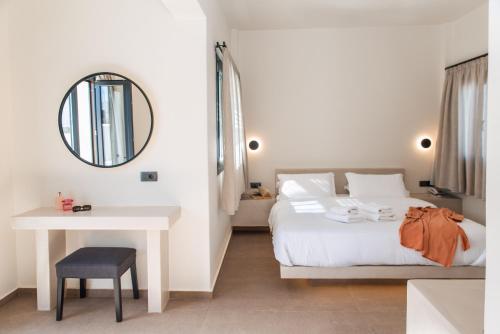 a bedroom with a bed and a table and a mirror at North Wind Luxury Suites in Oia