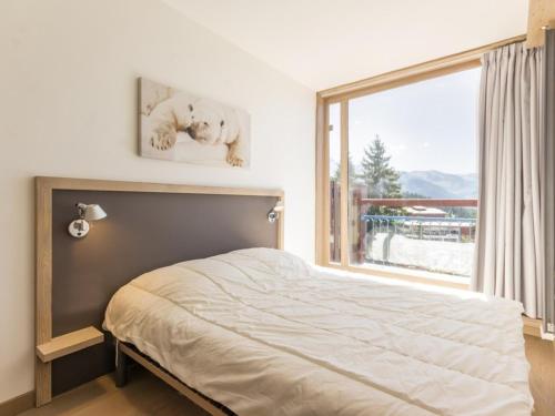 une chambre avec un lit et une grande fenêtre dans l'établissement Appartement rénové 6 pers · Balcon Sud-Ouest · Centre station Arc 1800 · Wifi gratuit - FR-1-346-343, à Arc 1800