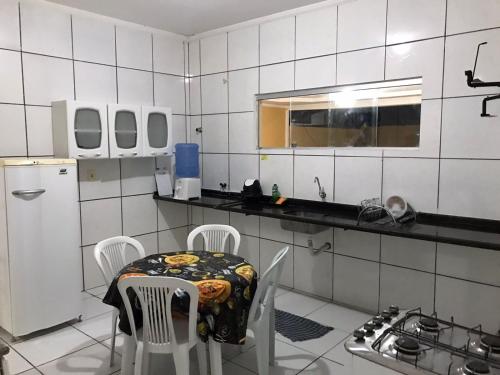 uma cozinha com uma mesa e cadeiras em Casa Park Massangano em Petrolina