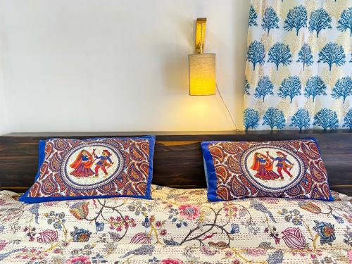 a bedroom with a bed with two pillows on it at Comfort and Cozy in Orchha
