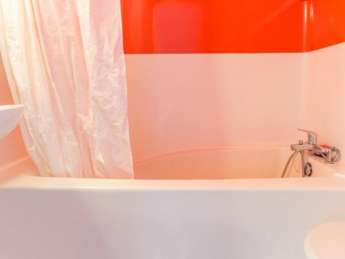 La salle de bains est pourvue d'une baignoire avec rideau de douche. dans l'établissement Studio cabine 5 pers · Ski aux pieds · Balcon · Plein centre - FR-1-346-425, à Arc 1800