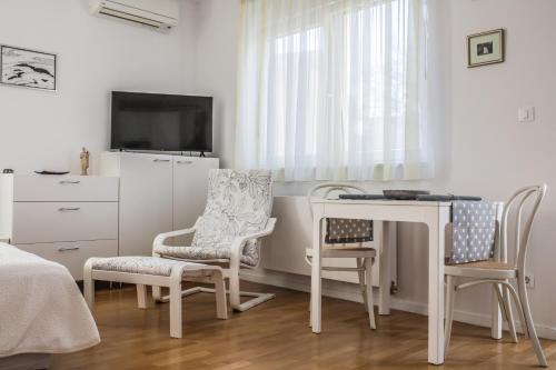 een slaapkamer met een tafel en stoelen en een televisie bij Apartman BeBe in Zagreb