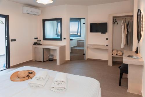 una camera d'albergo con letto bianco e bagno di North Wind Luxury Suites a Oia