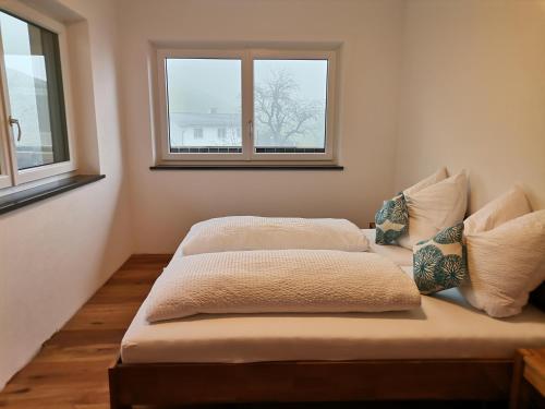 dwa łóżka w pokoju z dwoma oknami w obiekcie Ferienwohnungen Margreiter Birgit w mieście Hart im Zillertal